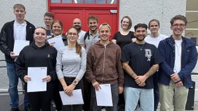 Zwölf junge Menschen stehen vor dem Ausbildungszentrum der Malteser und halten ihre Zertifikate in Händen (Foto Alicia Haller für Malteser).