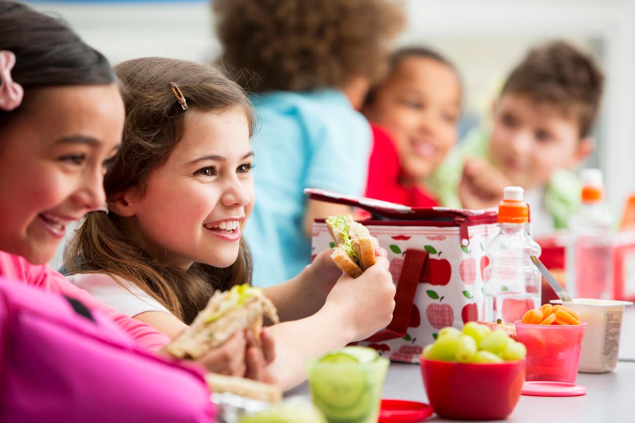 Kindergruppe sitzt am Tisch und frühstückt.