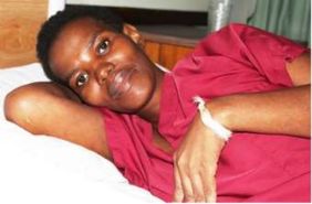 Xolile rests in red clothing on a hospice bed; original photograph from newsletter no. 35 (2016), page 7.