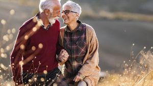 Es ist ein verliebtes und lachendes älteres Paar zu sehen.