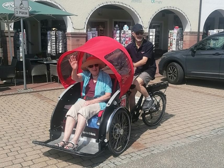 Die Rikscha wird von einem Piloten mit einem Gast fährt in Freudenstadt am Unteren Marktplatz