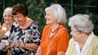 Mehrere ältere Frauen sitzen zusammen und lachen