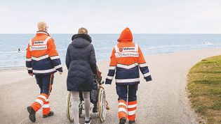 Ehrenamtliche begleiten einen Menschen am Lebensende zu einem letzten Ausflug ans Meer. Foto: Bettina Fürst-Fastré