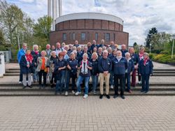 Gruppenfoto der Ehrenamtlichen auf der Treppe mit der Kolumbariumskirche im Hintergrund