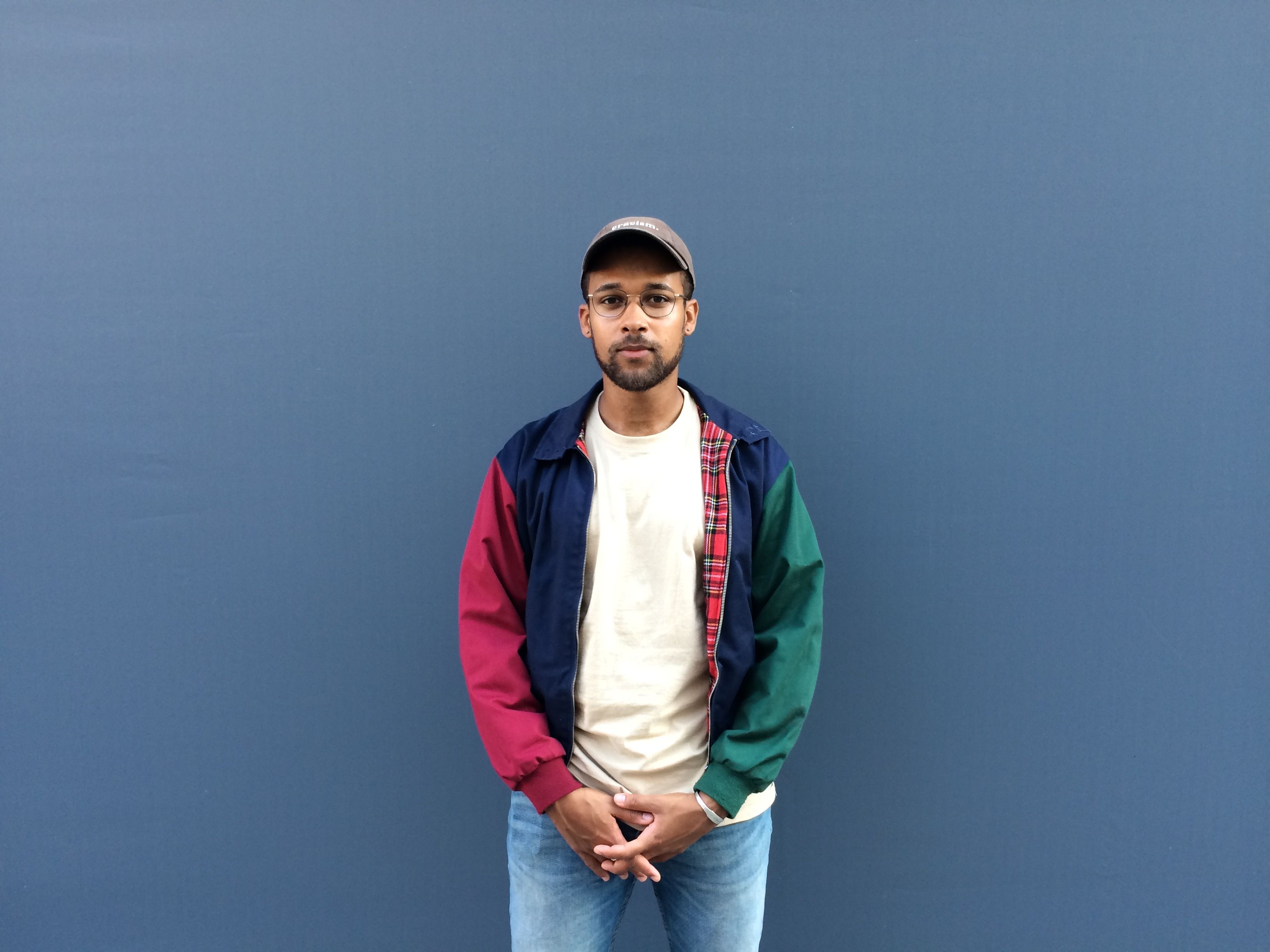 Portraitbild von David vor blauer Wand