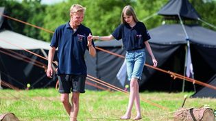 Ein Mitarbeiter der Malteser Jugend spielt mit einem Mädchen im Grünen.