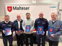 fünf Malteser halten Chronik der Malteser Abersfeld 