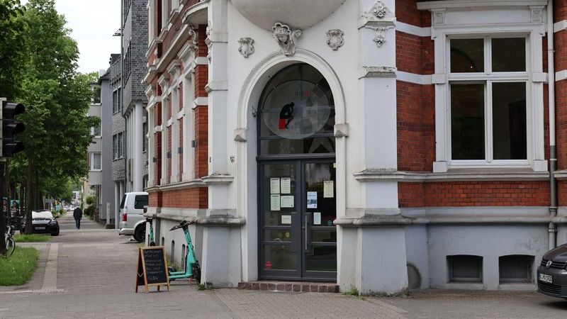 Von außen sieht man den Eingang eines Restaurants in einem Altbau in der Stadt.