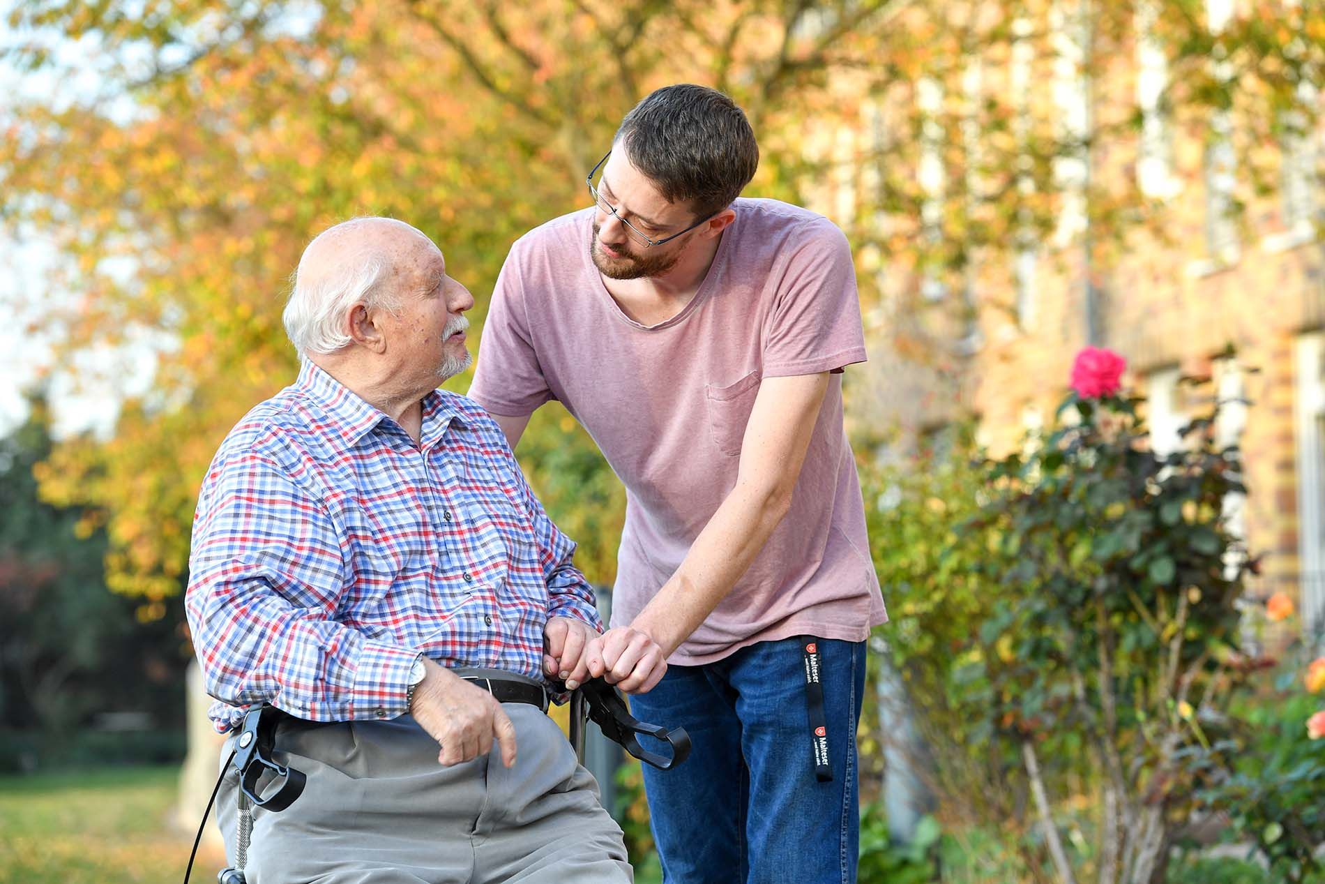 Pfleger und Bewohner gehen spazieren im Park 