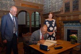 Klaus Deitmaring trägt sich stellvertretend für alle Mitarbeitenden in das Goldene Buch der Stadt Flensburg ein