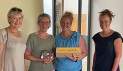 4 Frauen stehen nebeneinander und freuen sich über die Spende