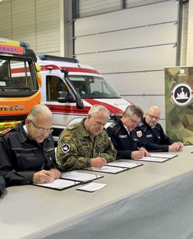 V. l.n.r.: Oliver Meermann, Bundesvorstandsmitglied der Johanniter-Unfall-Hilfe, Generaloberstabsarzt Dr. Ralf Hoffmann und Albrecht Prinz von Croy, Vizepräsident des Malteser Hilfsdienstes, unterzeichnen in Berlin den Vertrag zur privilegierten Partnerschaft im Sanitätsdienst zwischen den beiden Hilfsorganisationen und der Bundeswehr. Rechts: Der Bereichsleiter der Malteser Notfallvorsorge, Markus Bensmann. 