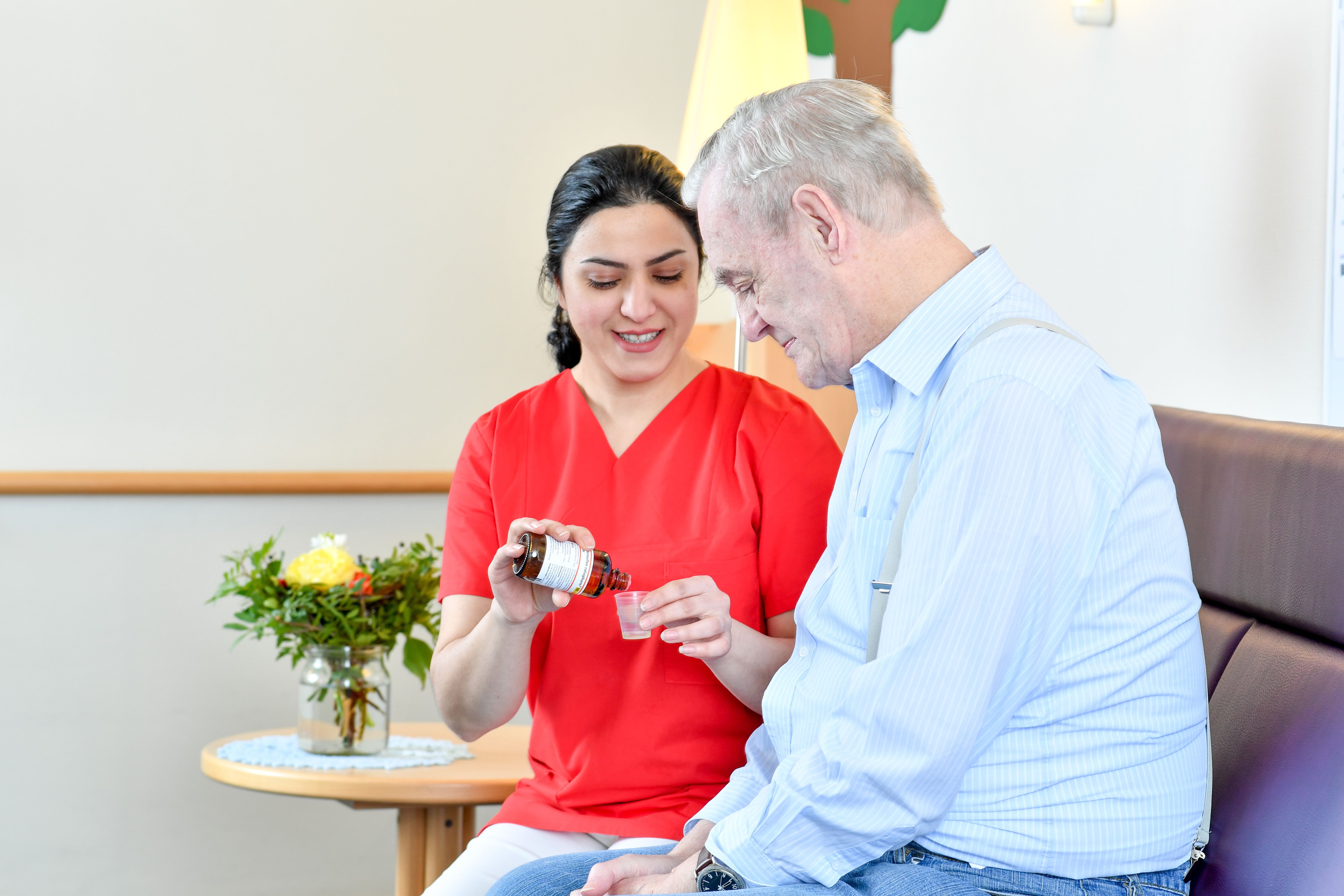 Pflegerin verabreicht Bewohner Medizin