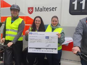 Die Gewinner halten einen Check in Händen