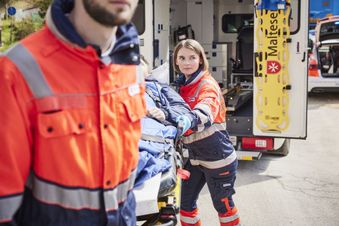 Eine Frau und ein Mann schieben eine Rettungstrage. Foto: Kirchner