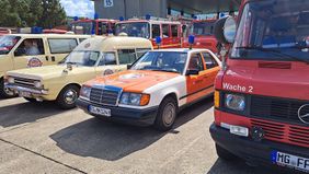 Mehrere Oldtimer-Einsatzfahrzeuge stehen nebeneinander auf einem Parkplatz