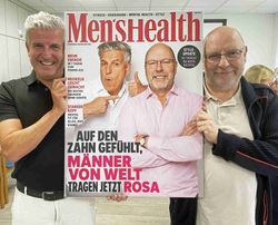Raphael Ebenhoch und Andreas Zahn halten ein Bild im Stil eines Zeitschriftencovers hoch