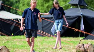 Ein Mitarbeiter der Malteser Jugend spielt mit einem Mädchen im Grünen.