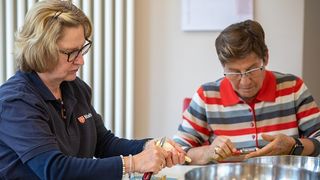 In der mobilen Küche der Malteser schälen zwei Frauen Kartoffeln. 