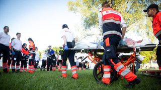 Bei einer Katastrophenschutzübung transportieren Malteser einen Verletzten auf einer Wiese