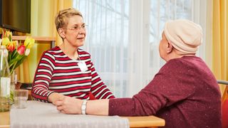 Zwei Frauen sitzen sich gegenüber und unterhalten sich