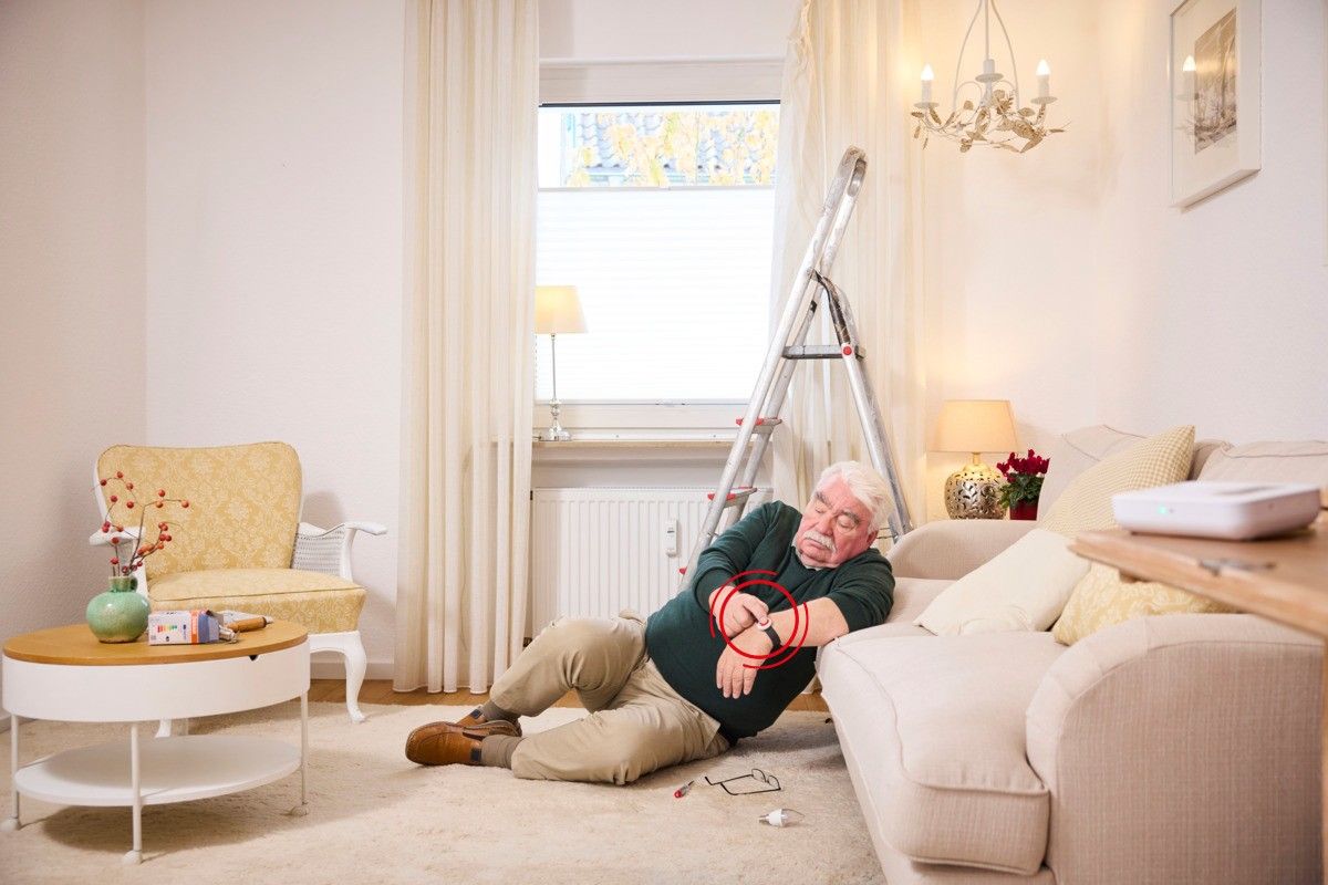 Ein Senior stürzt bei sich zuhause und betätigt den Hausnotruf Notfallknopf.