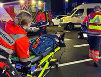 Zwei Personen in Malteser Einsatzkleidung schieben eine eine Trage mit einer verletzten Person