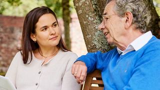 Älterer Mann und jüngere Frau sprechen über Betreuungsverfügung. 