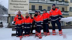 Acht Malteser Helfer stehen vor dem ehemaligen Hotel im Schnee..