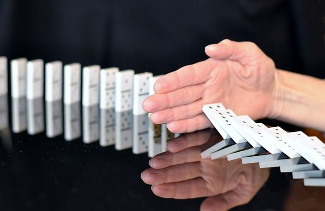 Hand hält Dominosteine auf.