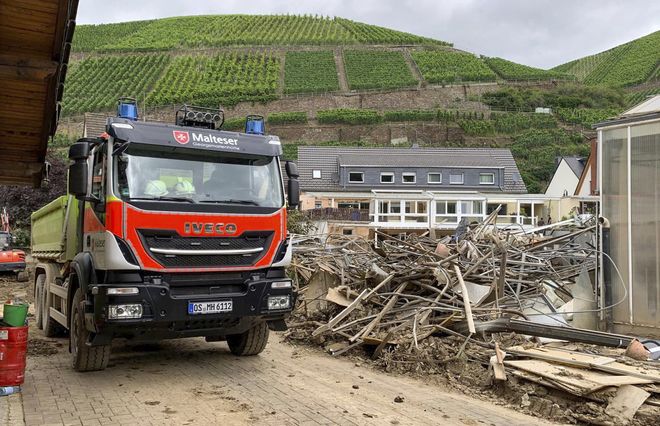Ein Malteser LKW steht neben einem Schutthaufen im Katastrophengebiet