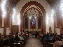 Das Foto zeigt den Innenraum der Sankt Josef Kirche. Musiker geben ein Konzert. 