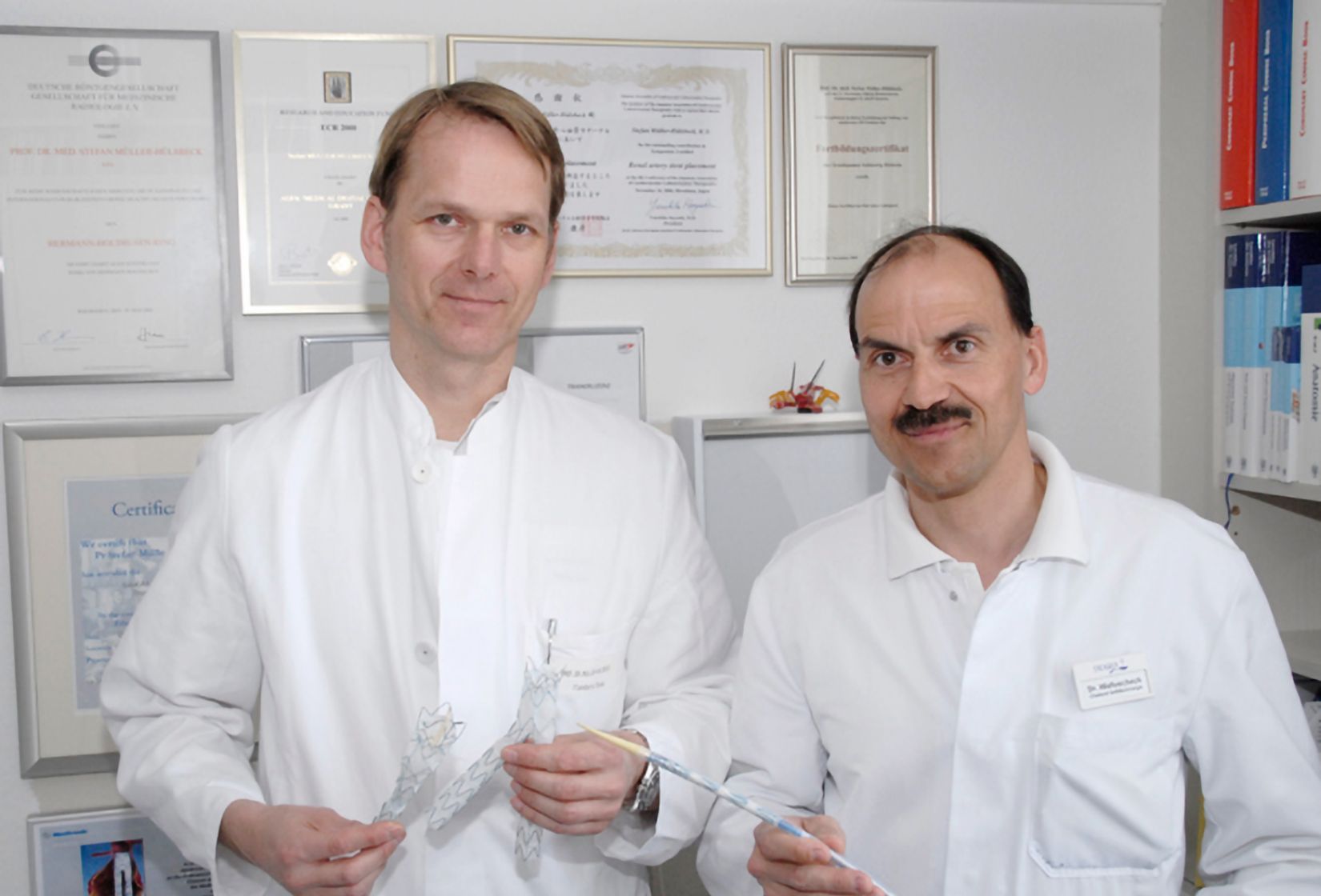 Zwei Ärzte halten zwei verschiedene Endoprothesen.
