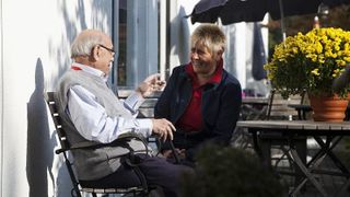 Mann und Frau im Gespräch auf der Terrasse.