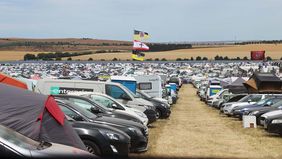 Blick über ganz viele Autos und Zelte.