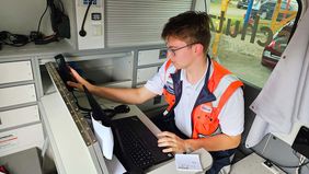 Ein junge Mann greift zum Telefonhörer.