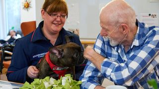 Ein Hund zu Besuch in einer Senioreneinrichtung