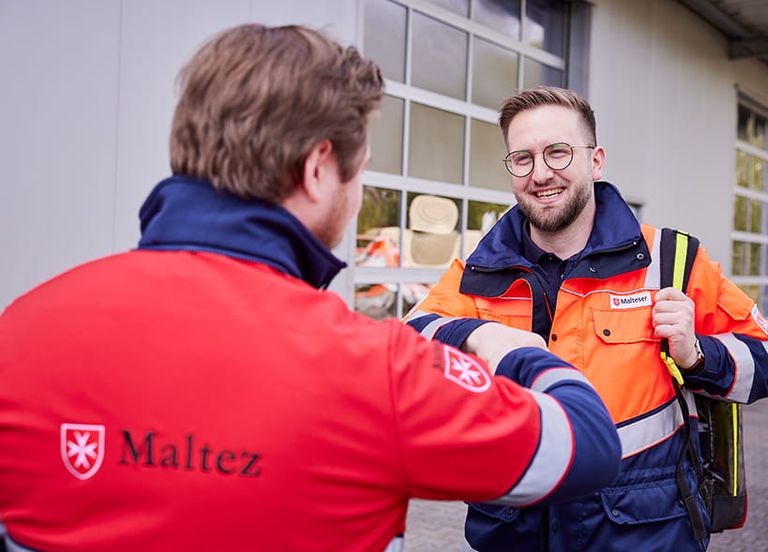 2 Mitarbeiter aus dem Malteser Auslandsdienst geben sich die Hand.