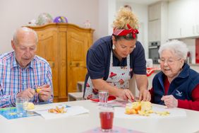 Eine Malteserin kocht mit zwei älteren Menschen