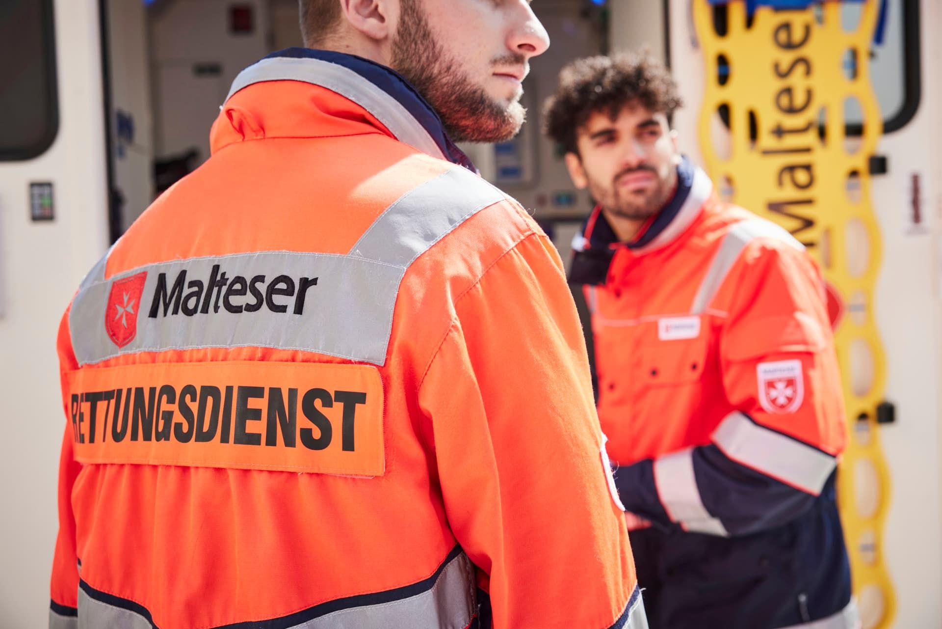Nahaufnahme: Zwei Malteser Rettungsdienst Mitarbeitende in Dienstkleidung.