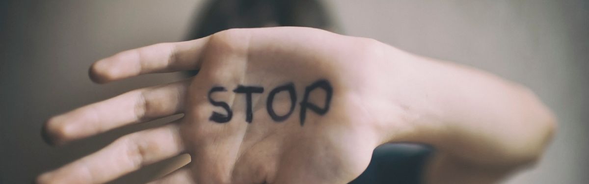 Vorgestreckte Handfläche mit der Aufschrift „Stop“