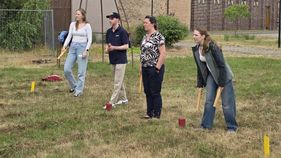 Gruppe von vier Leuten stehen nebeneinander und spielen Wikingerschach