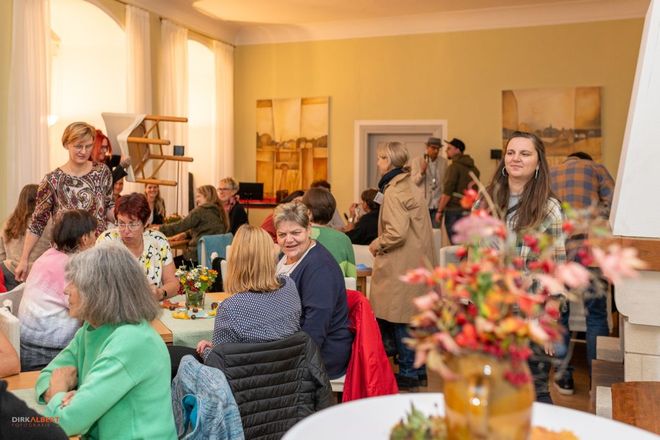 Menschen sitzen gemütlich zusammen und reden miteinander.
