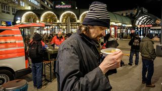 Obdachloser trinkt einen warmen Kaffee