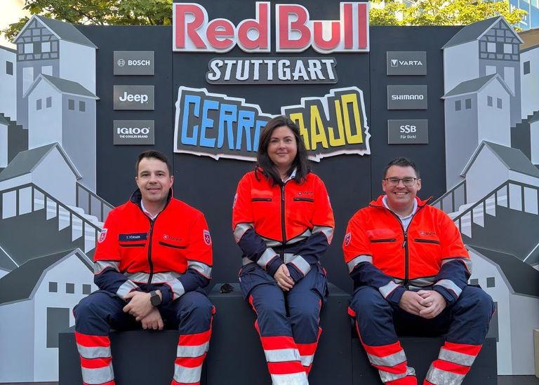 Drei Malteser vor dem Red Bull Schild