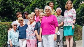 Eine Gruppe von Frauen steht auf einer Treppe draußen