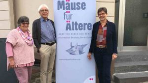Drei Senioren werben für ein Straßenplakat mit dem Titel: Mäuse für Ältere.