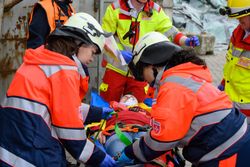 Zwei Malteser Sanitäter versorgen eine verletzte Person