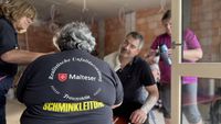 Drei Mitglieder der schminken gemeinsam einen Verletztendarsteller