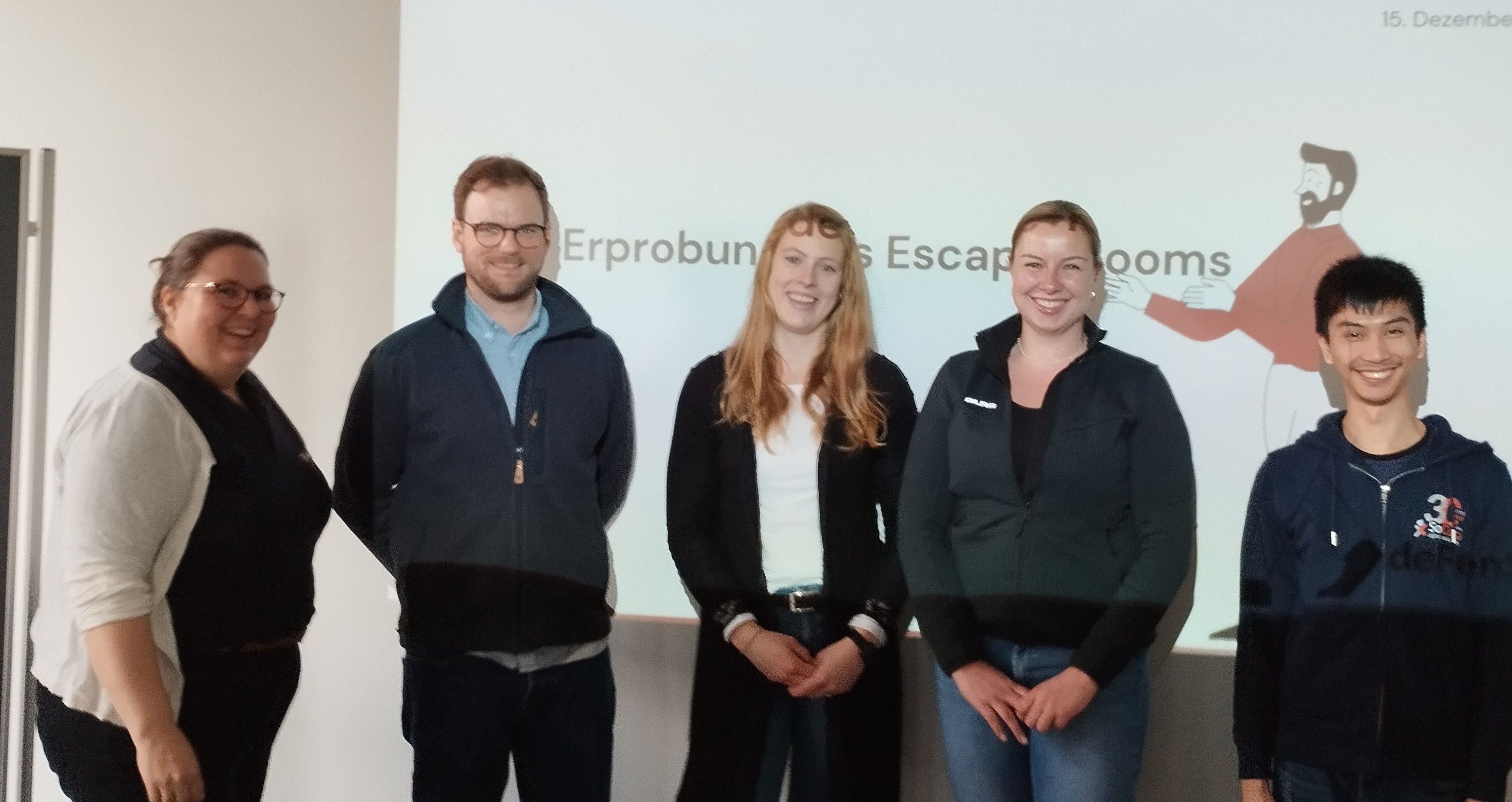 Projekt- und assoziierte Partner vor einer Leinwand zur Einleitung in den Escape Room